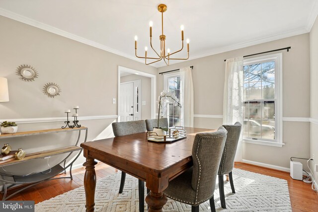 dining area with baseboards, an inviting chandelier, wood finished floors, and ornamental molding