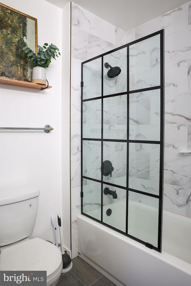 full bathroom featuring shower / bath combination with glass door and toilet