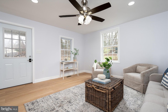 living room featuring a healthy amount of sunlight, baseboards, and wood finished floors