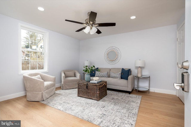 living room featuring baseboards, ceiling fan, light wood finished floors, and recessed lighting