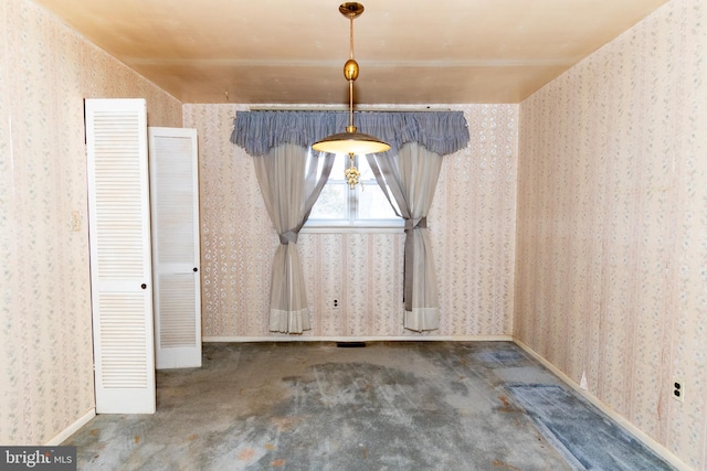 unfurnished dining area featuring carpet floors, wallpapered walls, and baseboards