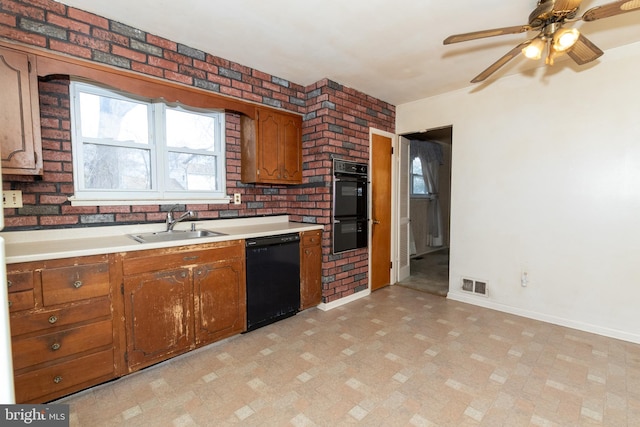 kitchen featuring brown cabinets, light countertops, visible vents, a sink, and black appliances