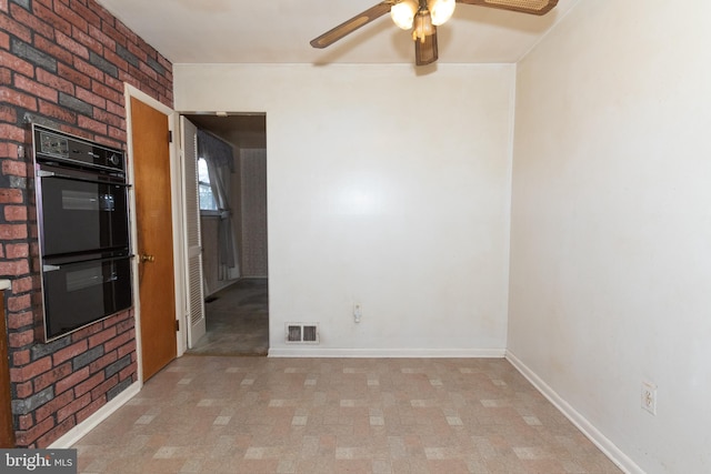 empty room with baseboards, visible vents, and ceiling fan