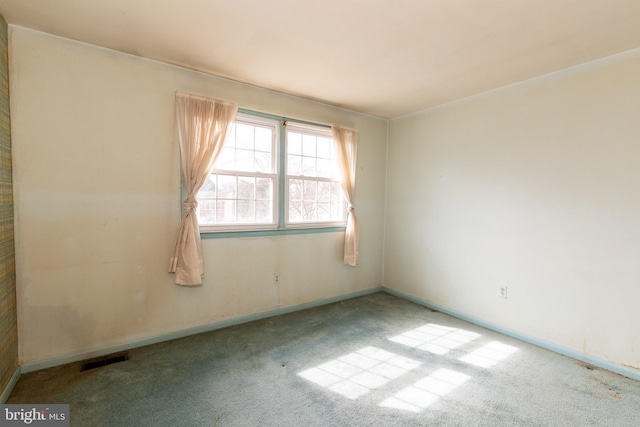 unfurnished room featuring carpet, visible vents, and baseboards