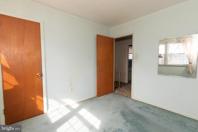 unfurnished bedroom featuring carpet floors and baseboards