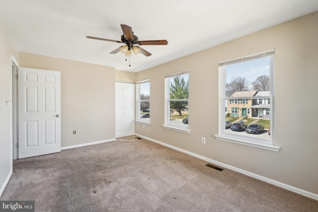 unfurnished bedroom with visible vents, ceiling fan, carpet, baseboards, and a closet