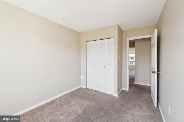 unfurnished bedroom with a closet, baseboards, and carpet