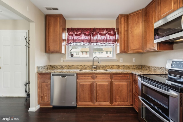 kitchen featuring brown cabinetry, visible vents, appliances with stainless steel finishes, and a sink