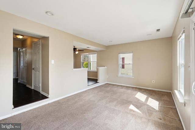 empty room featuring visible vents, baseboards, and carpet floors