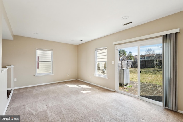 spare room featuring carpet flooring, baseboards, and visible vents