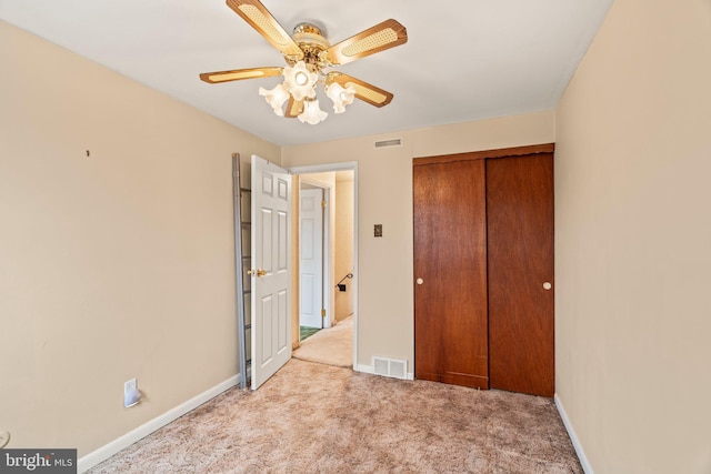 unfurnished bedroom featuring carpet flooring, baseboards, visible vents, and a closet