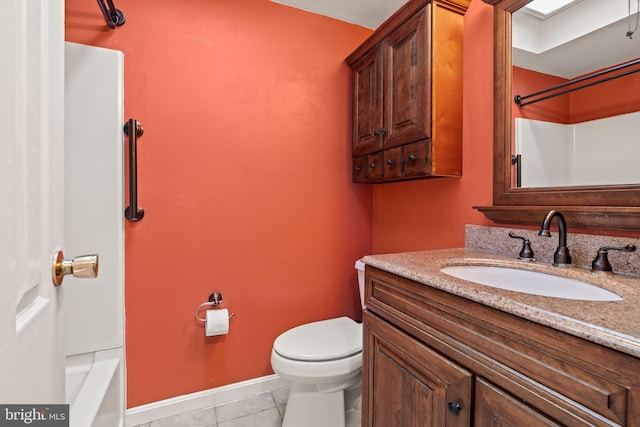 bathroom featuring tile patterned flooring, toilet, vanity, and baseboards