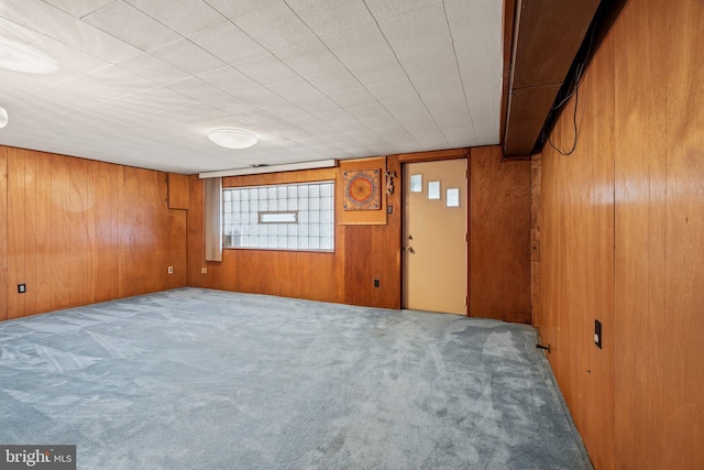 below grade area featuring wooden walls and carpet flooring