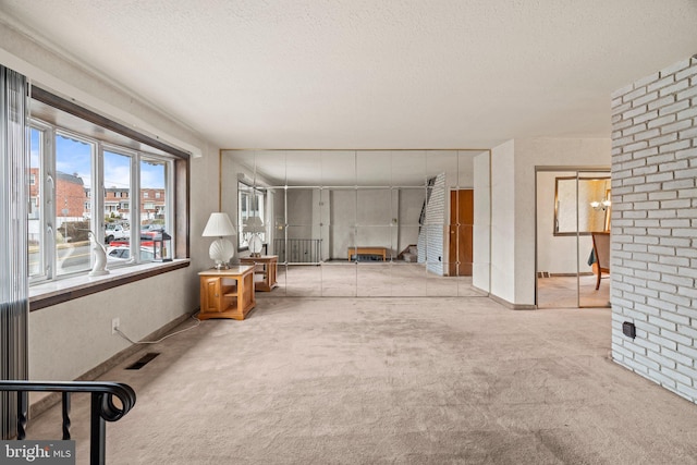 interior space featuring visible vents, carpet flooring, and a textured ceiling