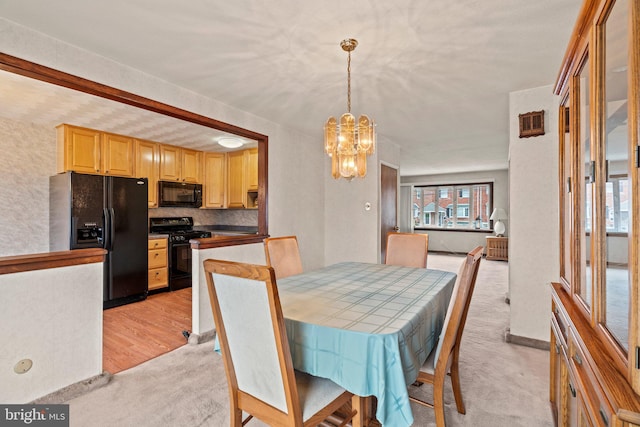 dining room featuring a wealth of natural light, light colored carpet, and an inviting chandelier