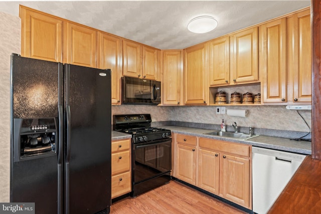 kitchen featuring light brown cabinets, open shelves, a sink, black appliances, and light wood-type flooring