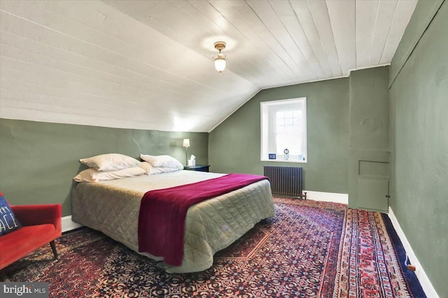 bedroom with lofted ceiling, radiator, and baseboards