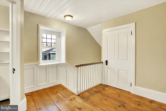 bonus room with light wood-style floors, wooden ceiling, wainscoting, and vaulted ceiling