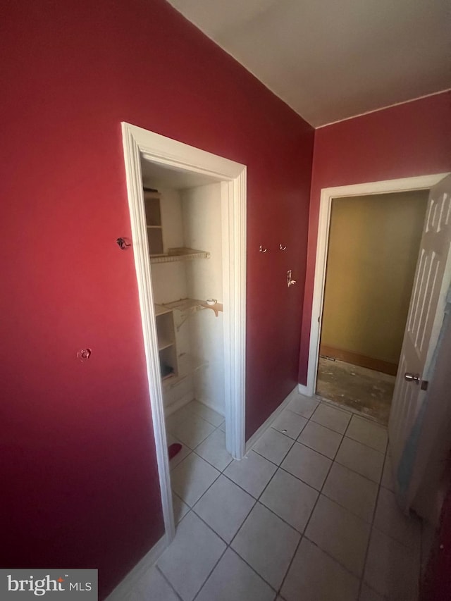 hall with light tile patterned floors and baseboards