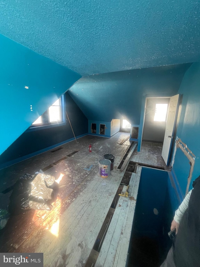 bonus room with vaulted ceiling and a textured ceiling