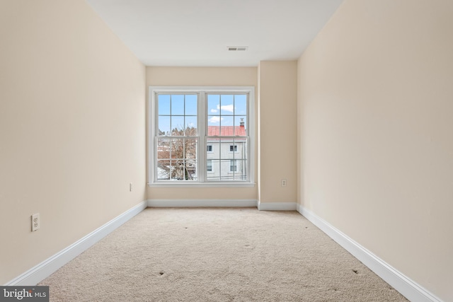 carpeted empty room featuring visible vents and baseboards