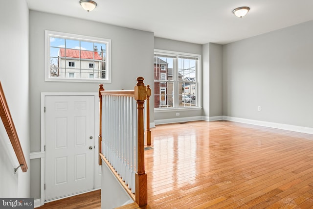 foyer featuring light wood-type flooring, visible vents, and baseboards