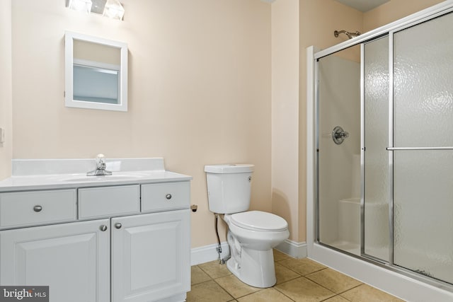 bathroom featuring toilet, a shower stall, vanity, tile patterned flooring, and baseboards