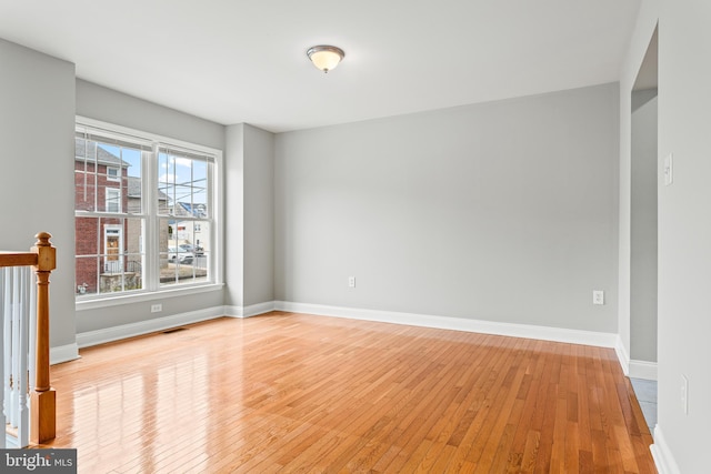 unfurnished room with baseboards, visible vents, and light wood-style floors