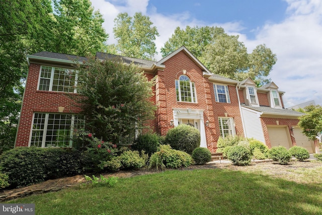 colonial inspired home with brick siding and a front lawn