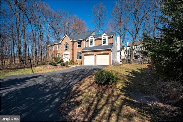 view of front of house with a front yard, a garage, and driveway