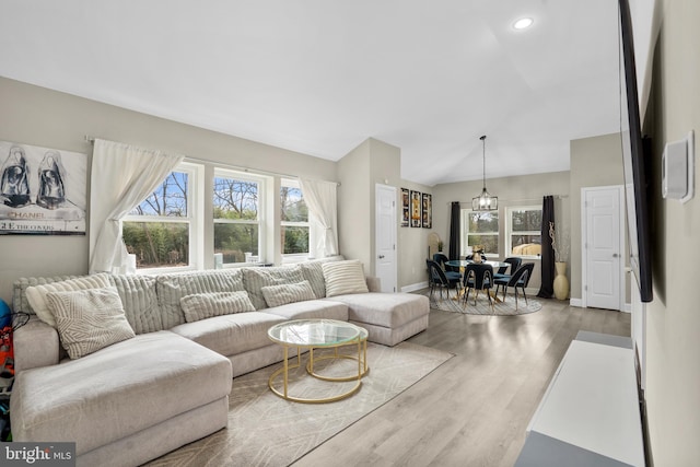 living area featuring lofted ceiling, wood finished floors, a wealth of natural light, and baseboards