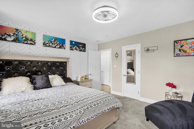 carpeted bedroom with an accent wall and baseboards