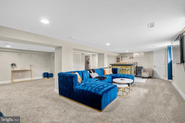 carpeted living area featuring baseboards, visible vents, and recessed lighting