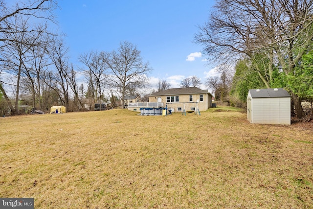 view of yard featuring a covered pool, an outdoor structure, and a storage shed