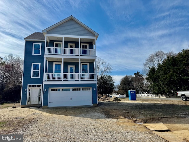 view of front of property featuring a balcony, driveway, and a garage