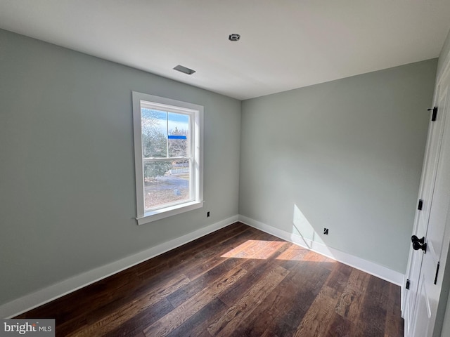 unfurnished room with baseboards and wood finished floors