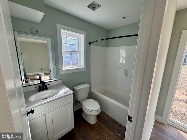 bathroom featuring shower / washtub combination, vanity, toilet, and wood finished floors