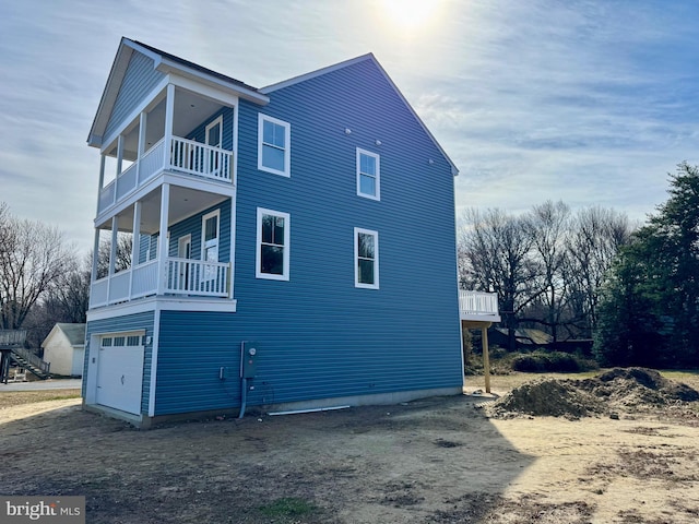 view of property exterior featuring a garage, driveway, and a balcony