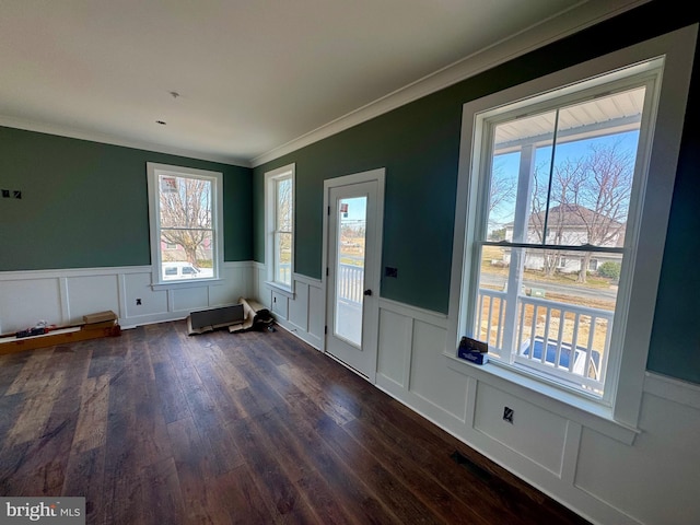 entrance foyer featuring a wainscoted wall, dark wood-type flooring, and crown molding