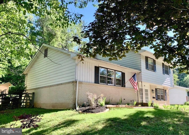 view of front of home featuring brick siding and a front yard