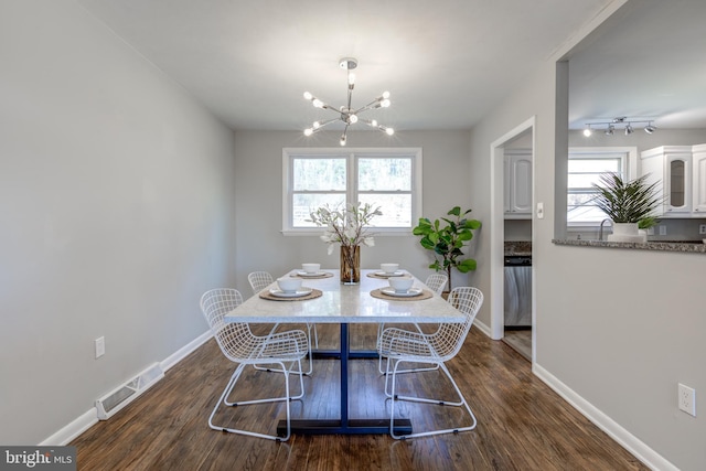 dining room featuring a wealth of natural light, visible vents, baseboards, and dark wood-style floors