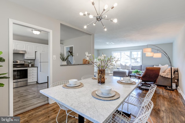 dining room featuring baseboards, an inviting chandelier, and dark wood-style flooring