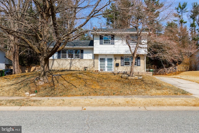 tri-level home featuring brick siding and fence