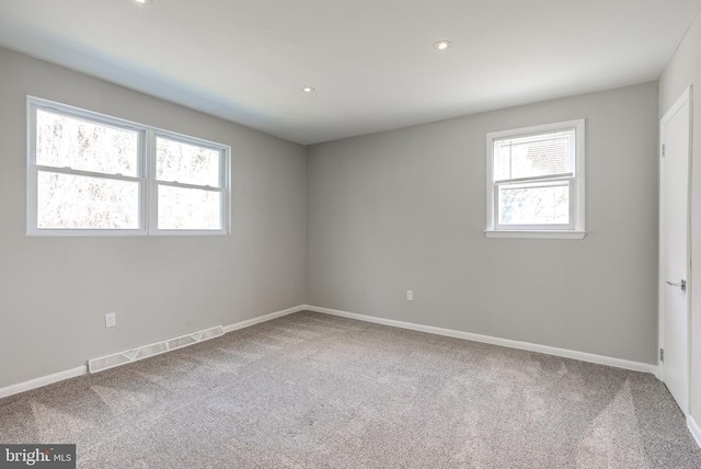 empty room with recessed lighting, carpet flooring, baseboards, and visible vents