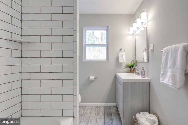 full bath with toilet, vanity, baseboards, and wood finished floors