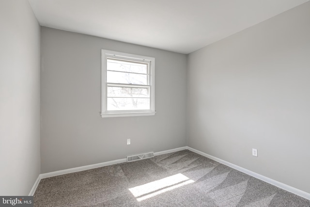 carpeted empty room with visible vents and baseboards