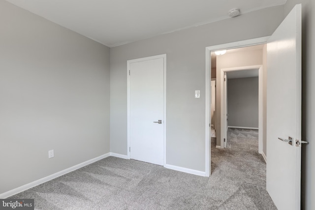 unfurnished bedroom featuring carpet flooring and baseboards