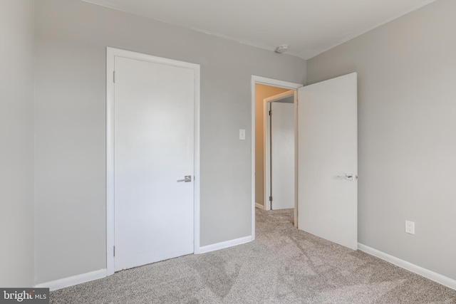 unfurnished bedroom featuring baseboards and carpet flooring