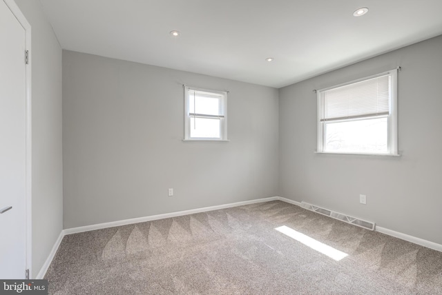 carpeted spare room featuring visible vents, recessed lighting, and baseboards