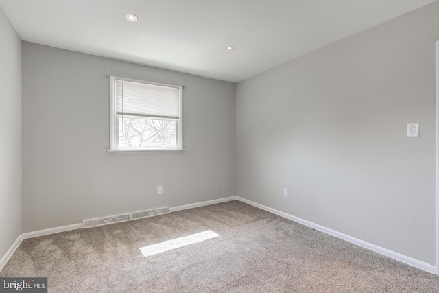 carpeted spare room featuring recessed lighting, visible vents, and baseboards